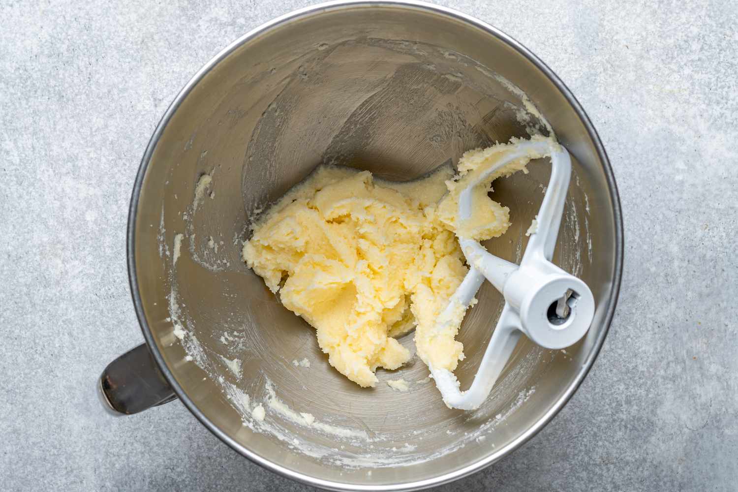 A stand mixer bowl with butter and sugar