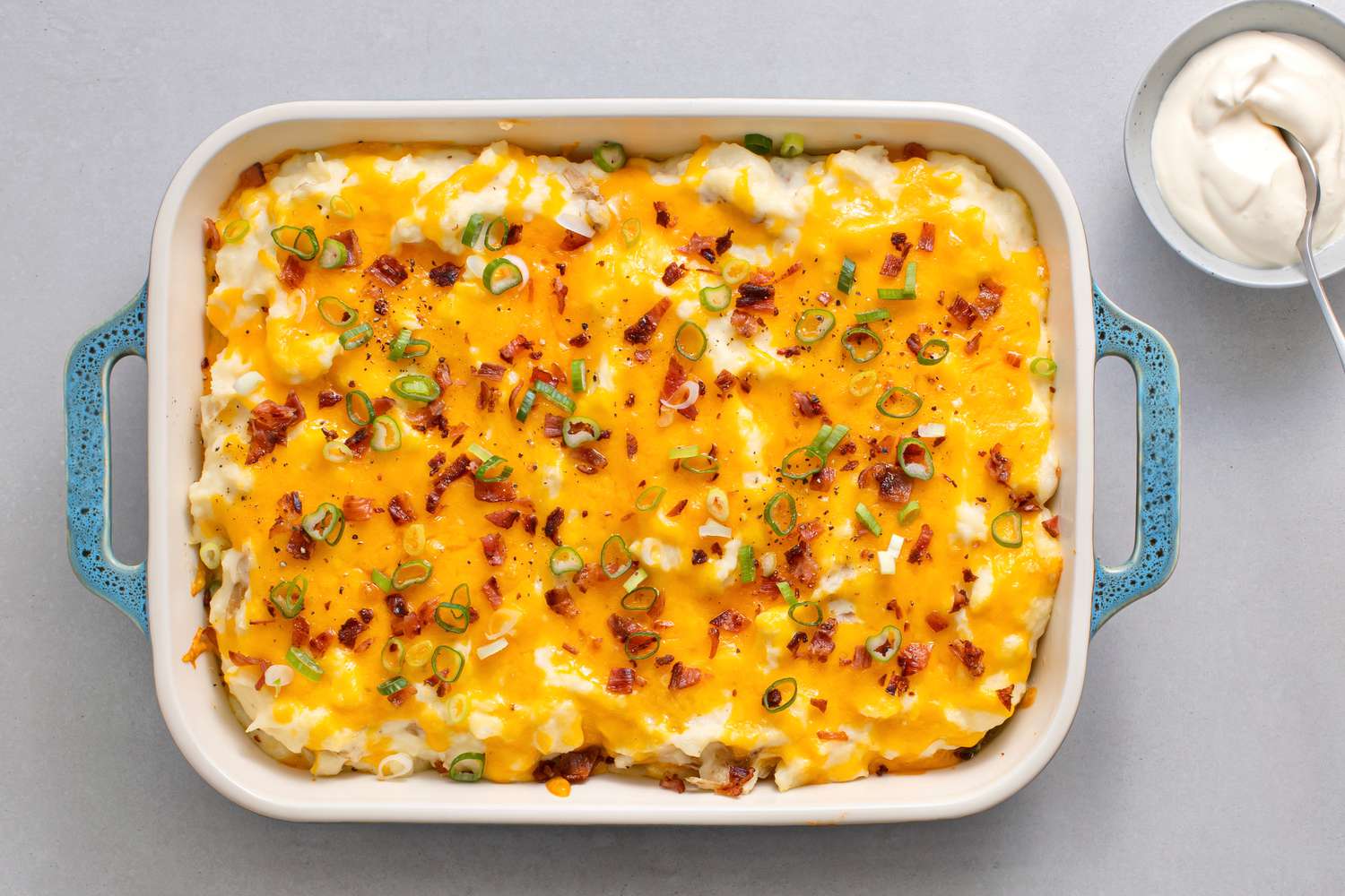 Loaded Smashed Potatoes in a baking dish 