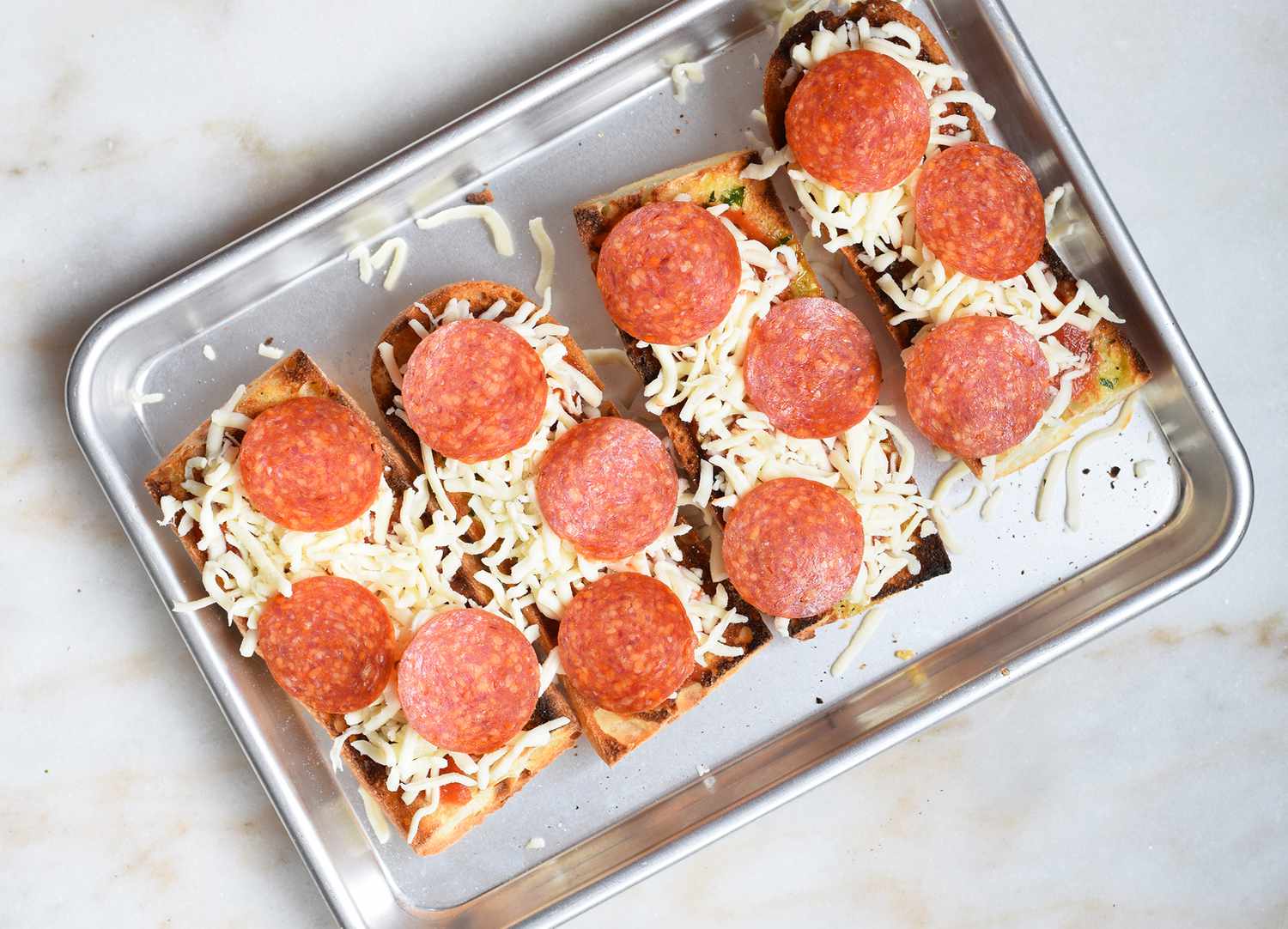 baguettes topped with sauce, cheese, and pepperoni