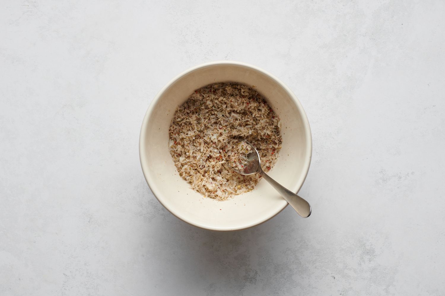 A small bowl of Parmesan, Italian seasoning, celery salt, garlic powder, and red pepper flakes