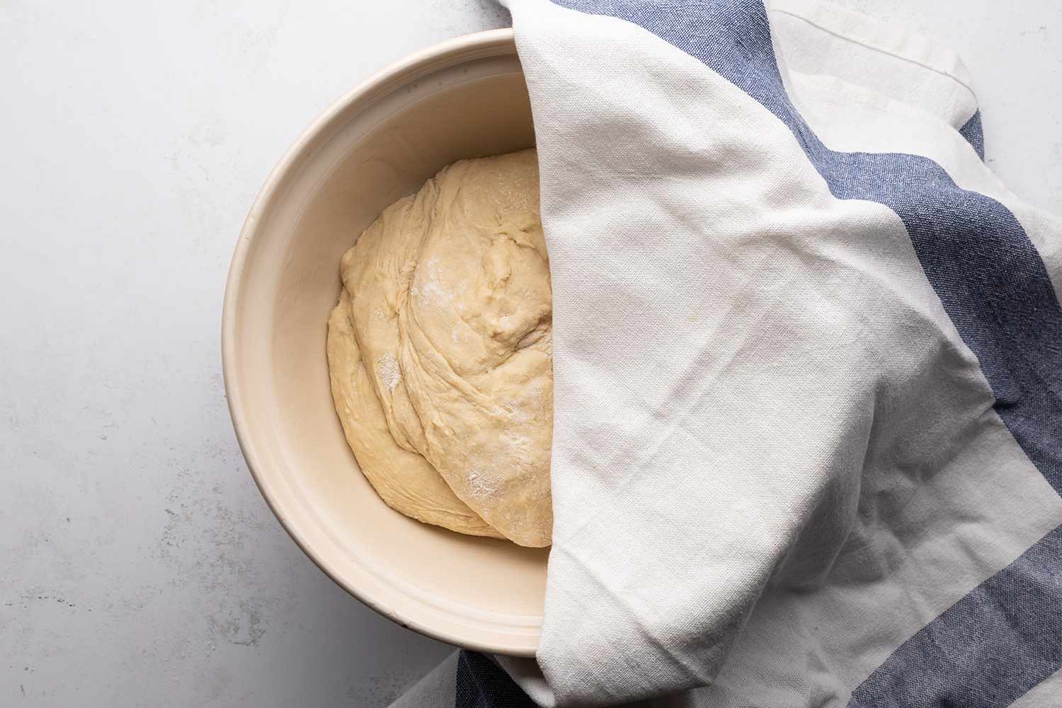 Dough in a bowl, covered with a towel 