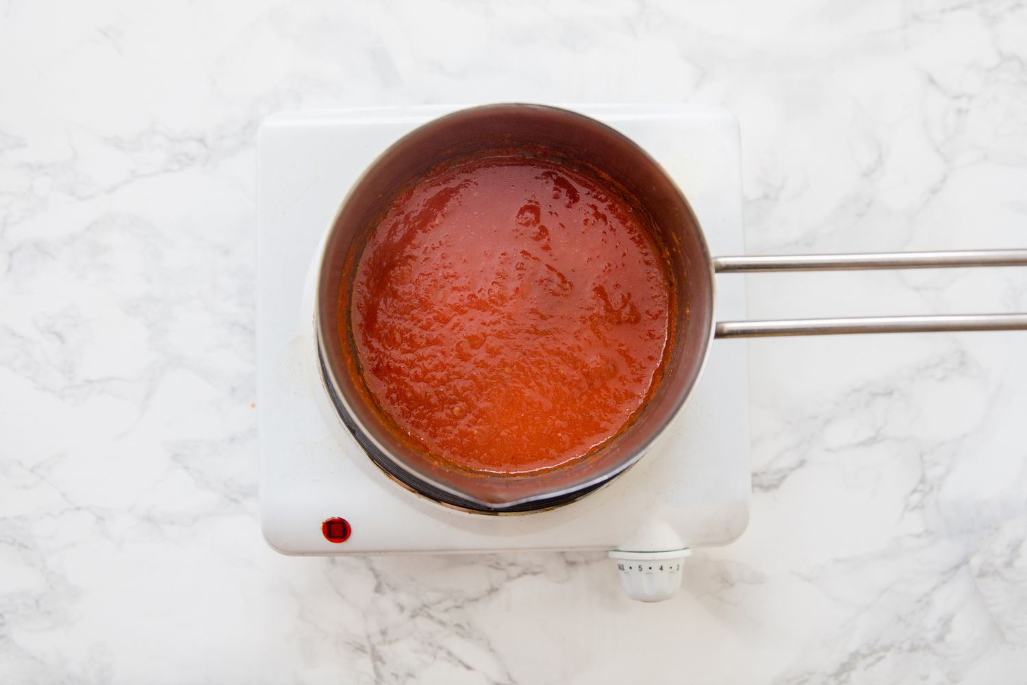 Red tomato sauce thickening in a saucepan for cabbage rolls