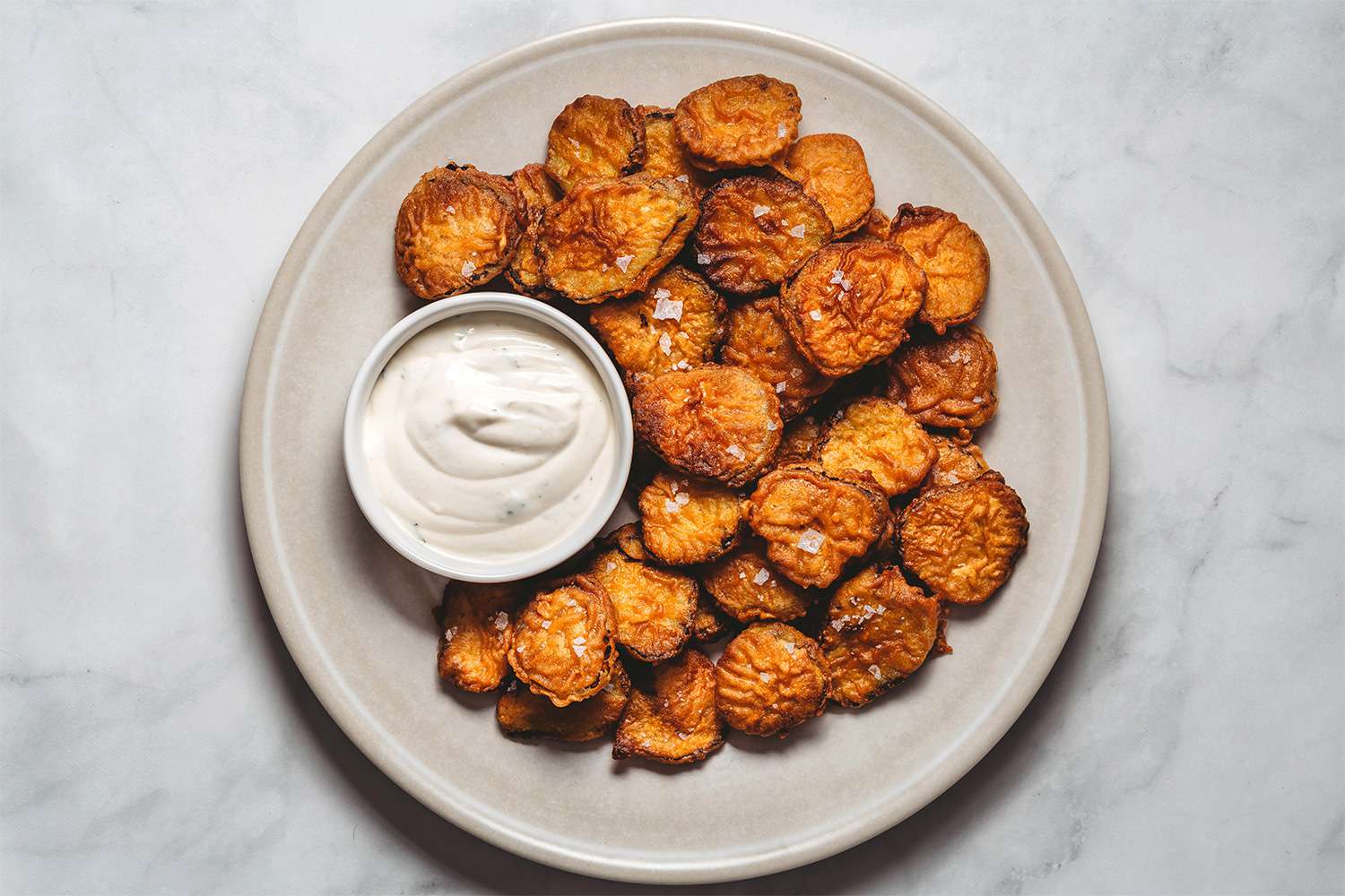 Fried Pickles with Buttermilk-Ranch Sauce on a platter 