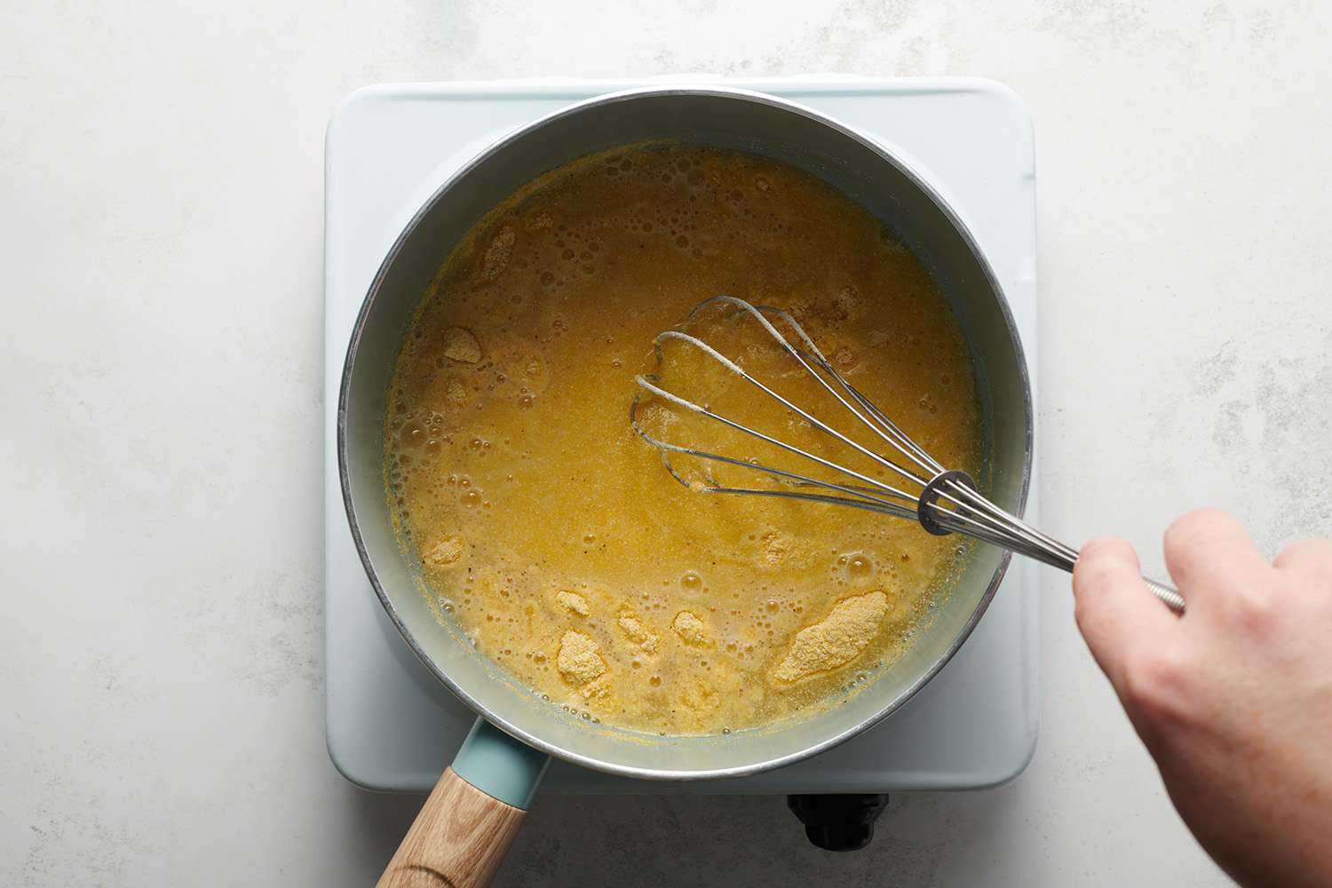 stirring cornmeal in water in a saucepan