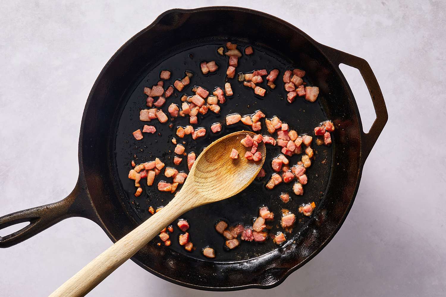 Pancetta cooking in a cast iron pan