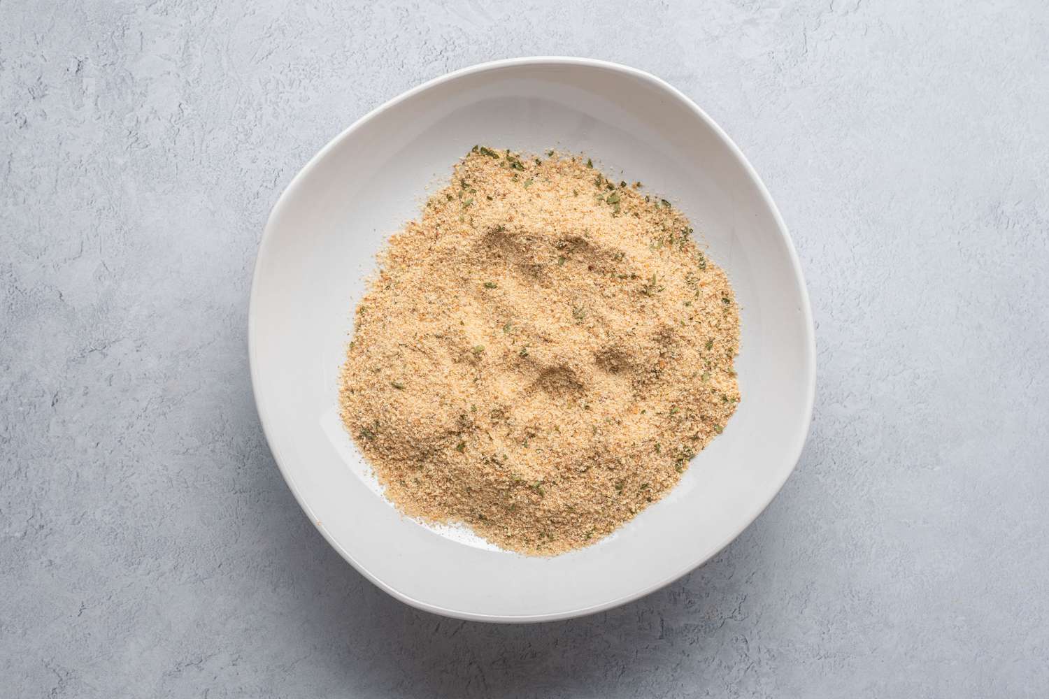 Seasoned breadcrumbs in a shallow white bowl