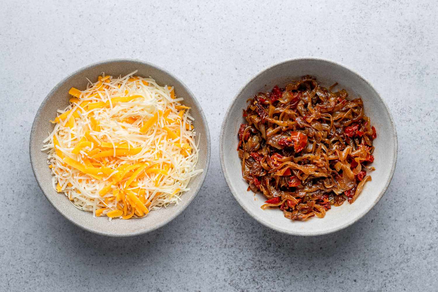 caramelized onions and other ingredients combined in bowl with cheese in separate bowl