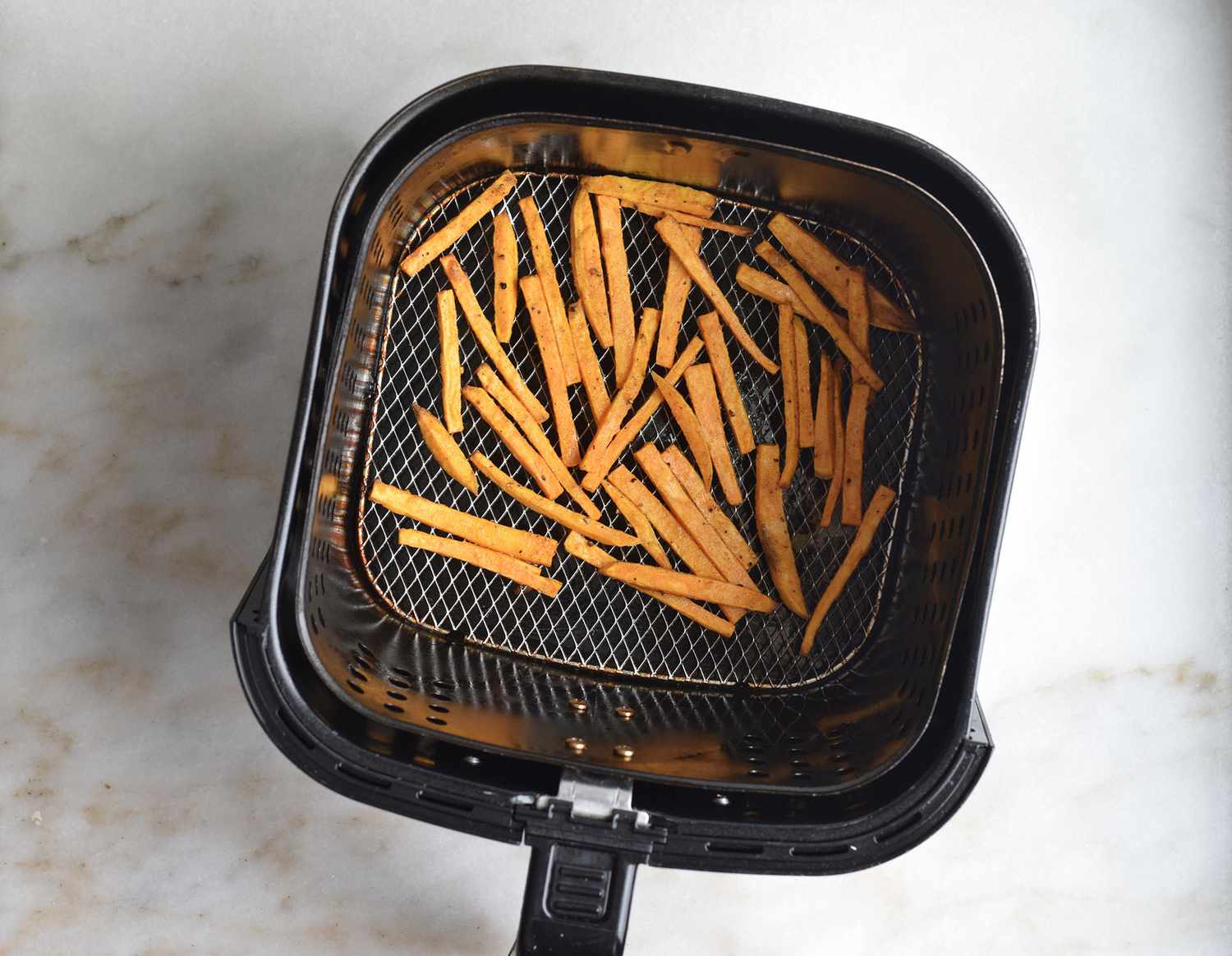 Sweet potato fries in an air fryer basket