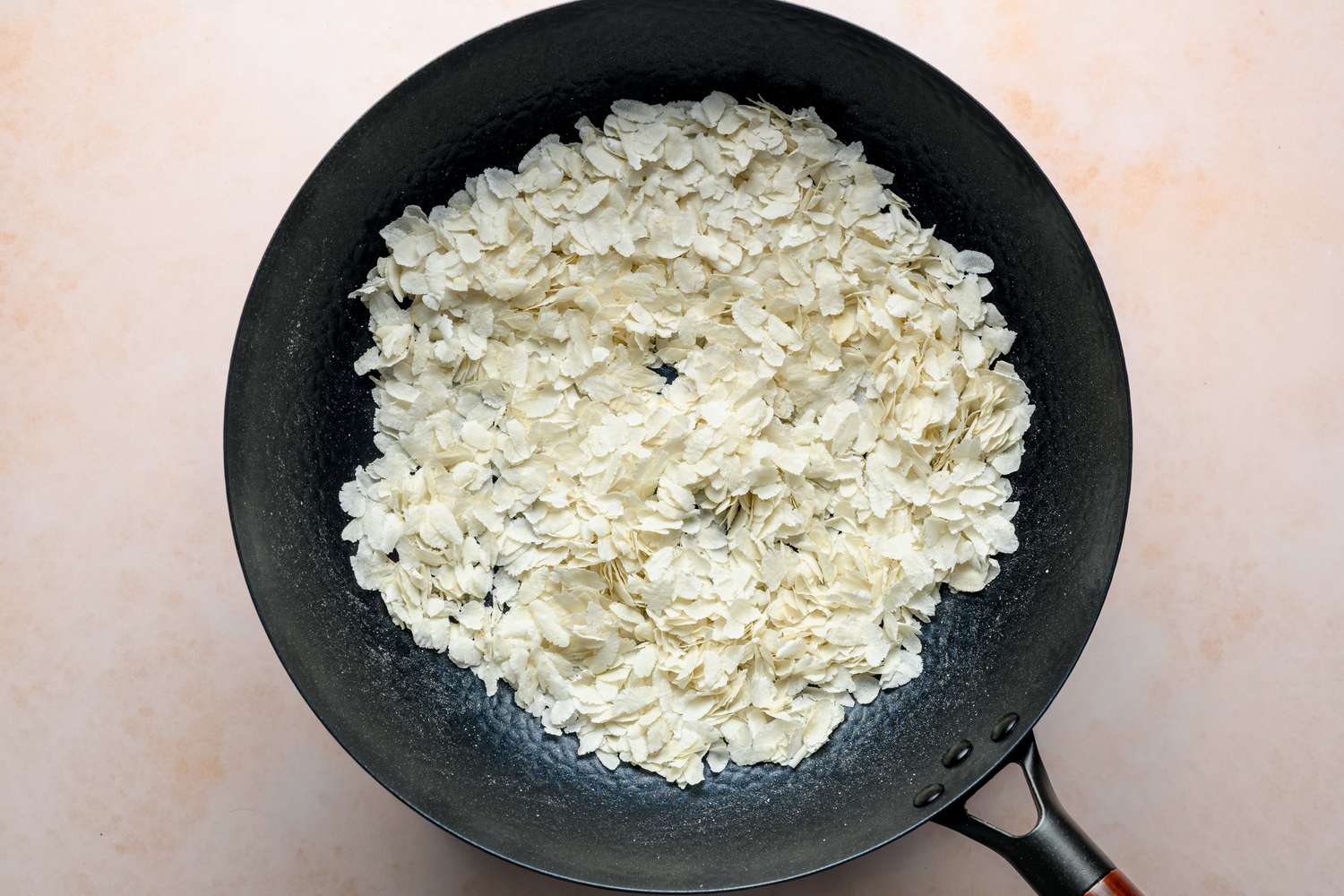 A large wok with flattened rice (poha)