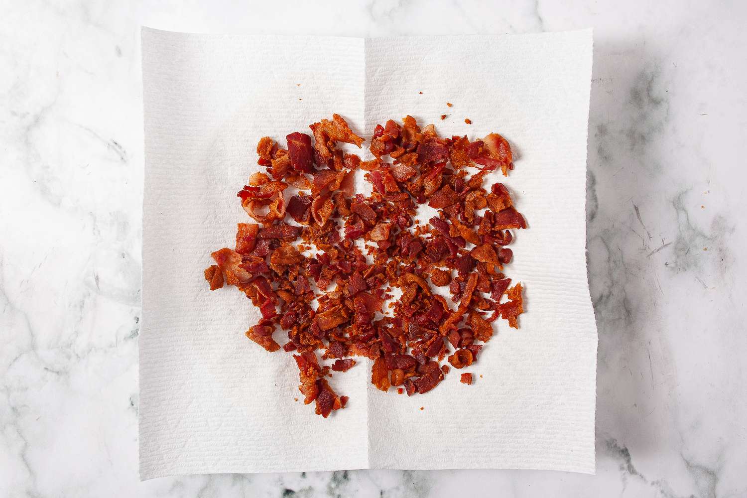 Crumbled bacon on a paper towel