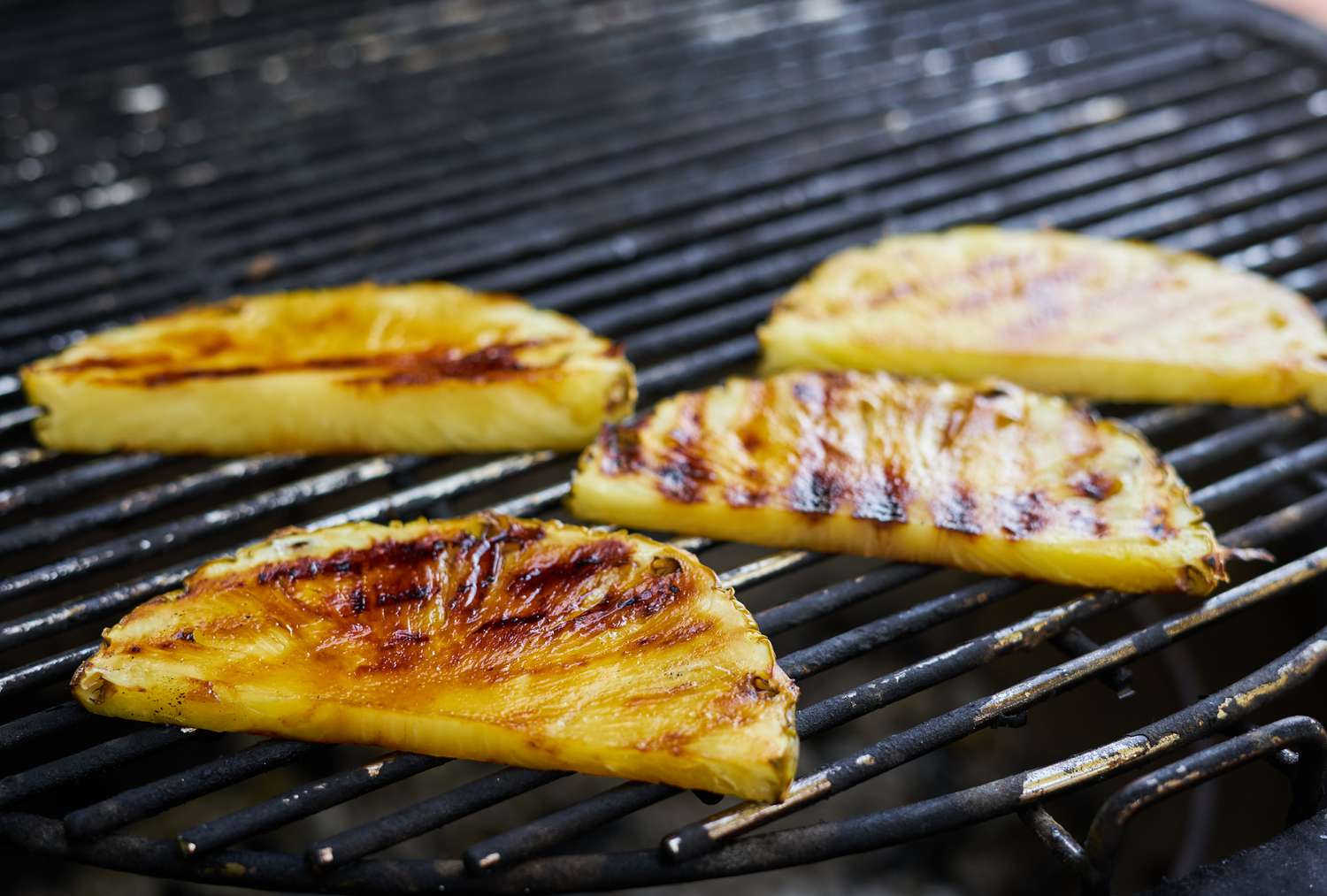Slices of honey-brushed pineapple on a grill