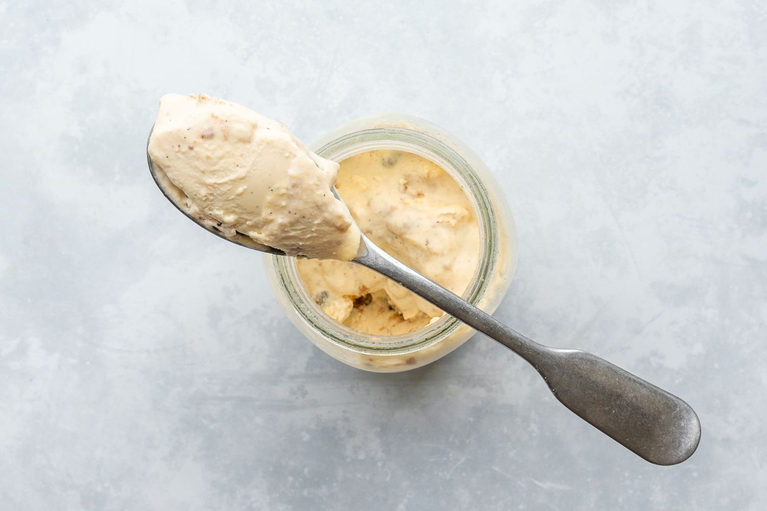A spoon holding a scoop of the ice cream mixture 