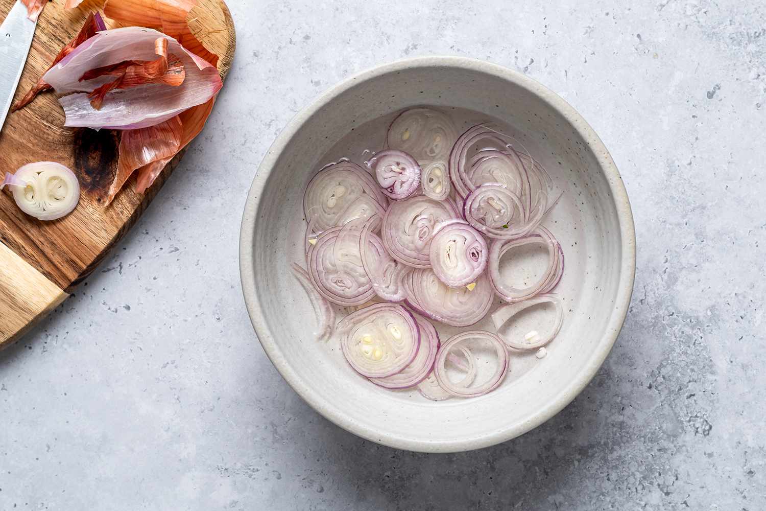 Sliced shallots in a bowl of water
