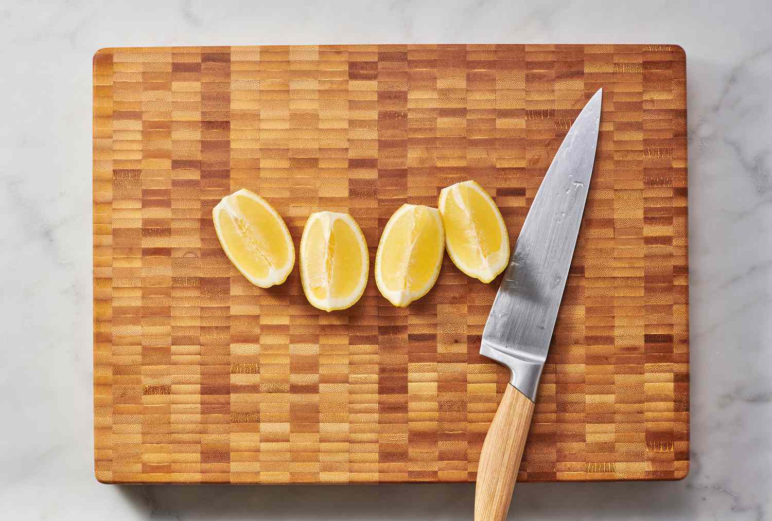 lemon cut into quarters on cutting board