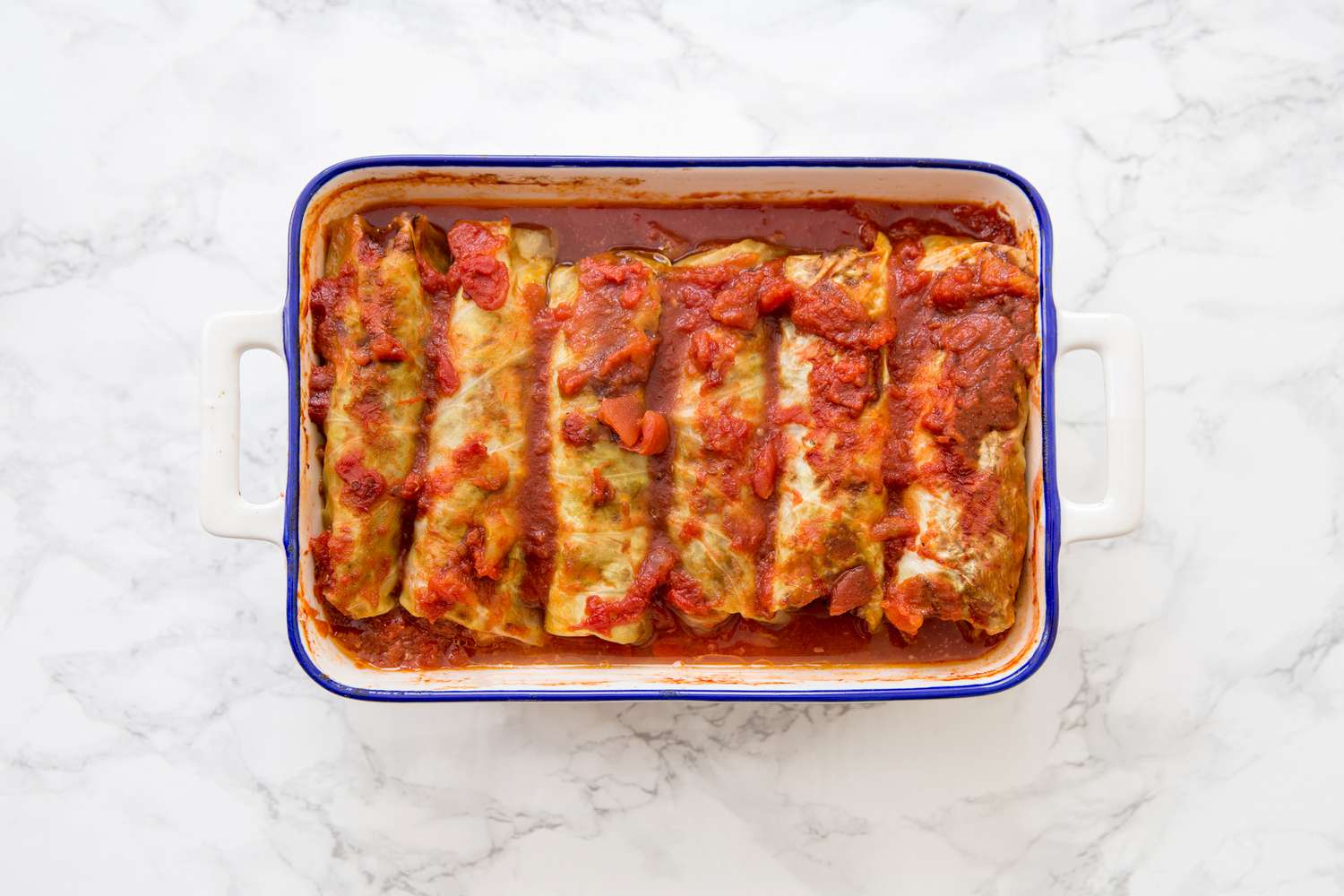 Baked cabbage rolls covered in tomato red sauce