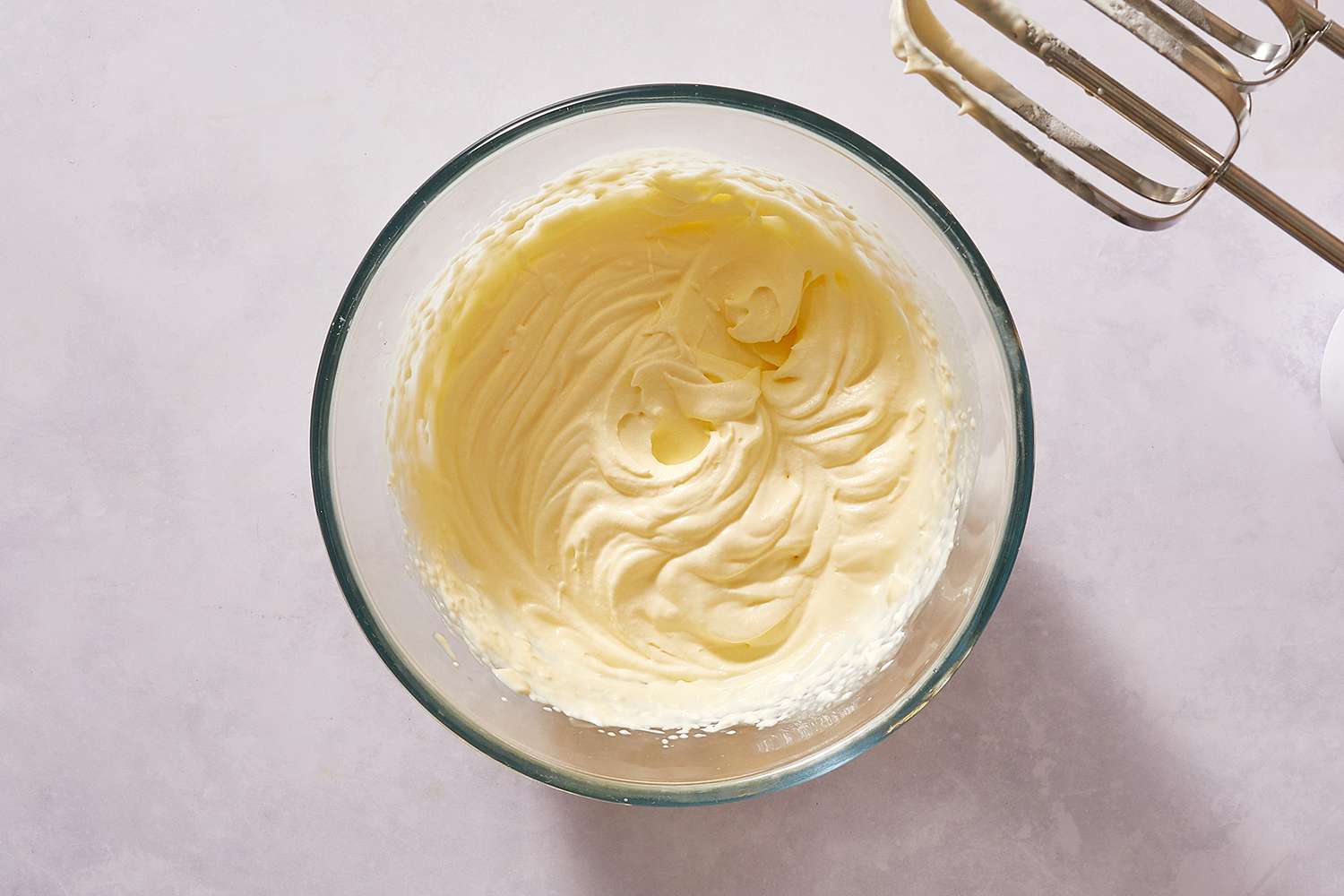 Egg white and cream mixture in a bowl with a hand mixer 