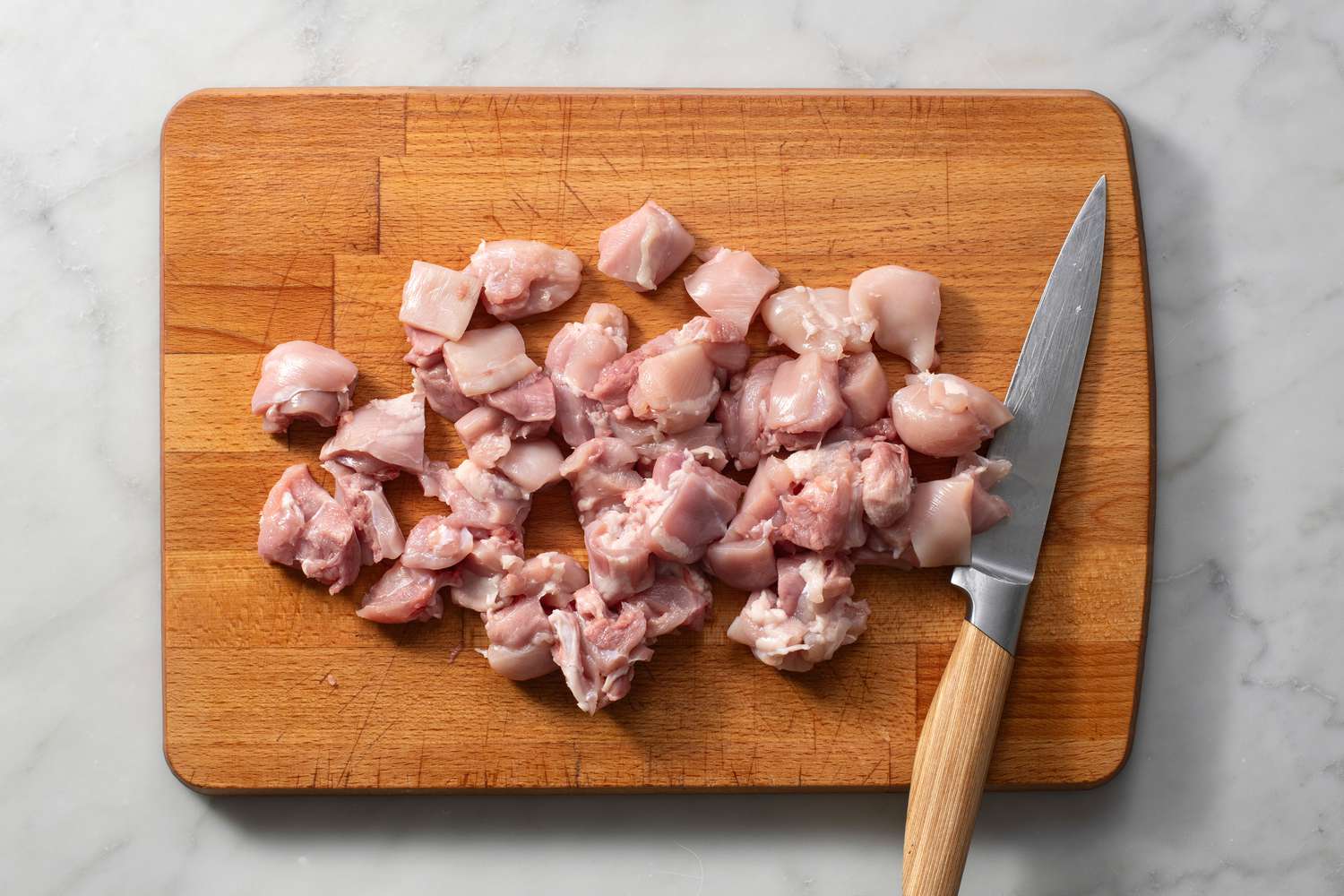 chicken thigh meat cut into bite size pieces on cutting board