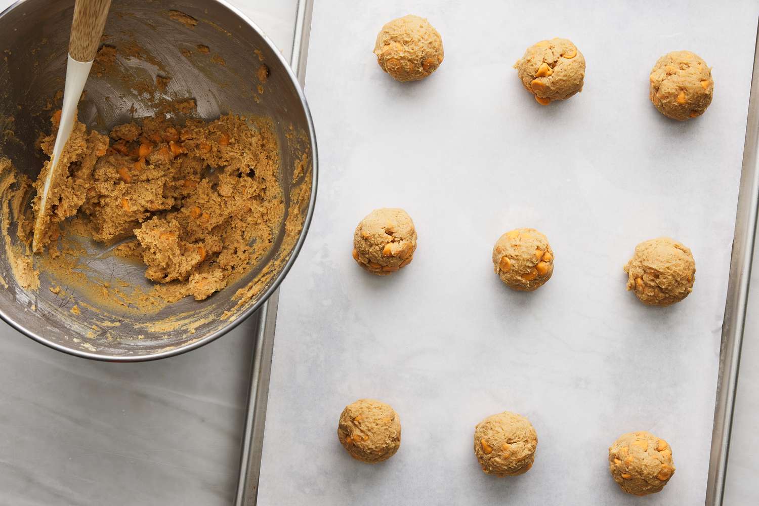 butterscotch cookie dough portioned into balls on parchment lined baking sheet