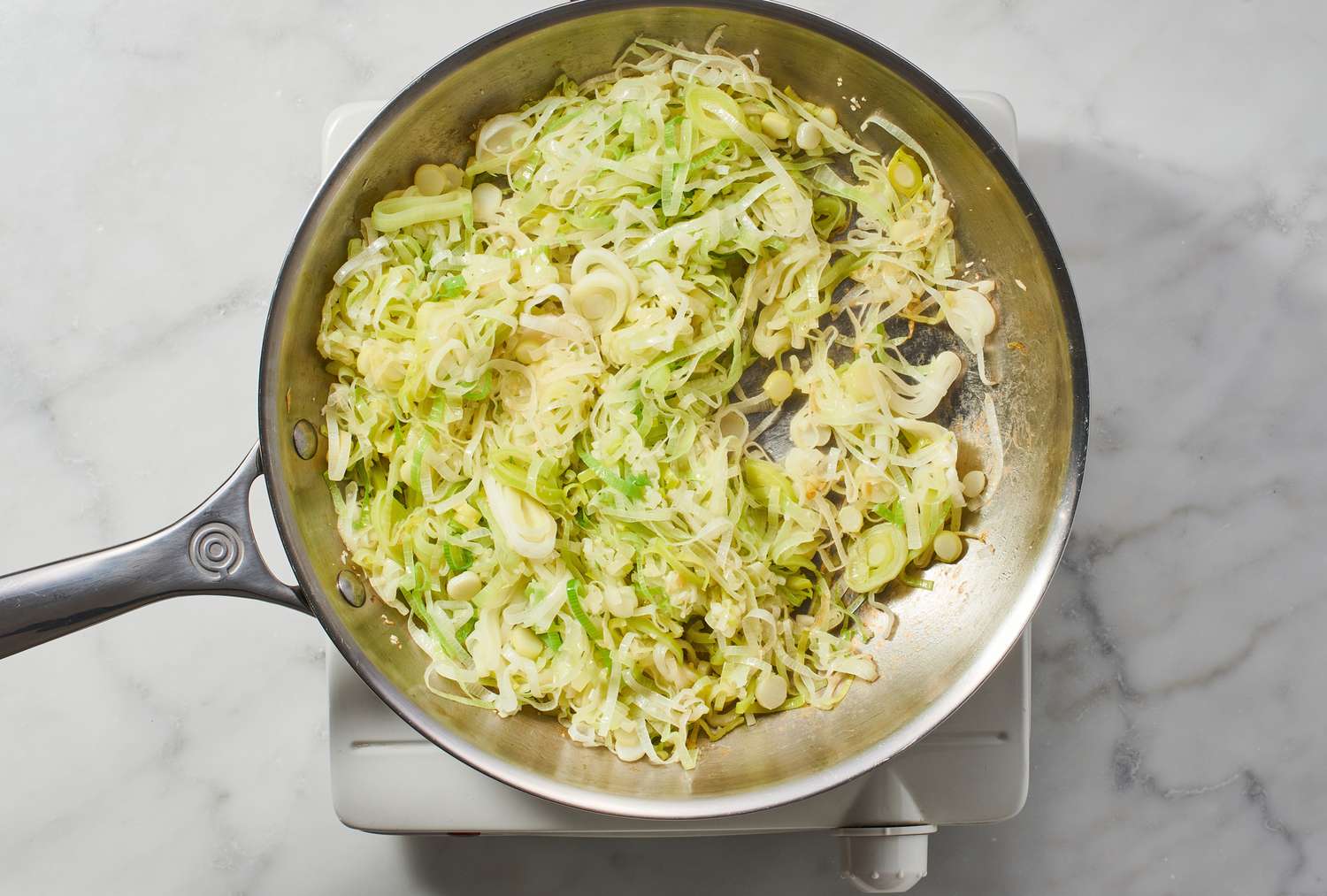 A large skillet with leeks and garlic