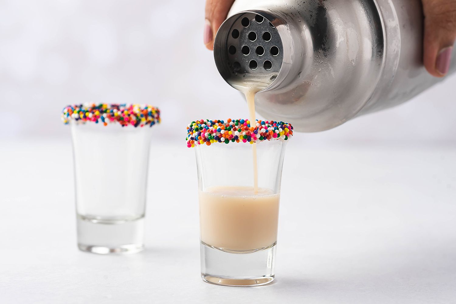 pouring birthday cake cocktail into shot glasses