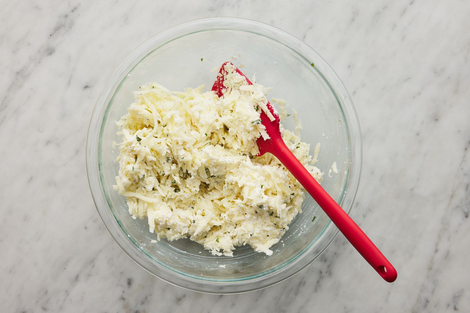 cheeses combined in a bowl with spatula