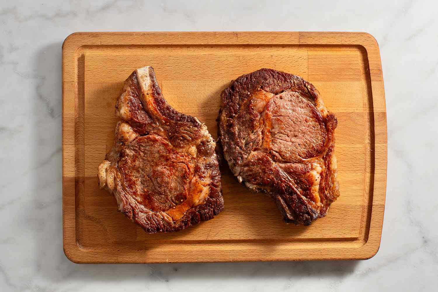seared steaks resting on wood cutting board