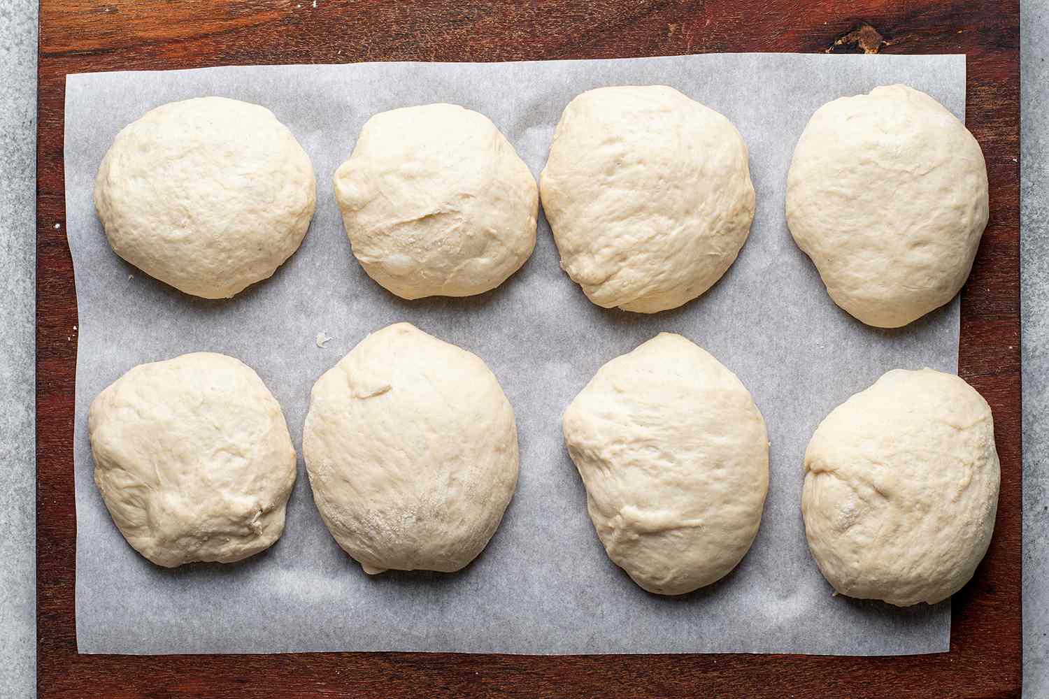 balls of bread dough on a lined baking sheet
