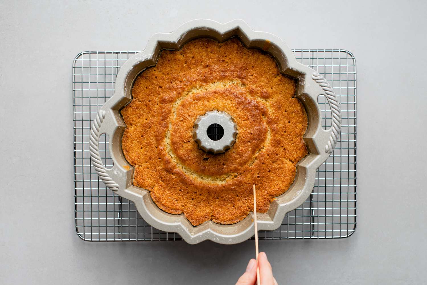 Kentucky Bundt cake in a pan over a rack pierced with small holes