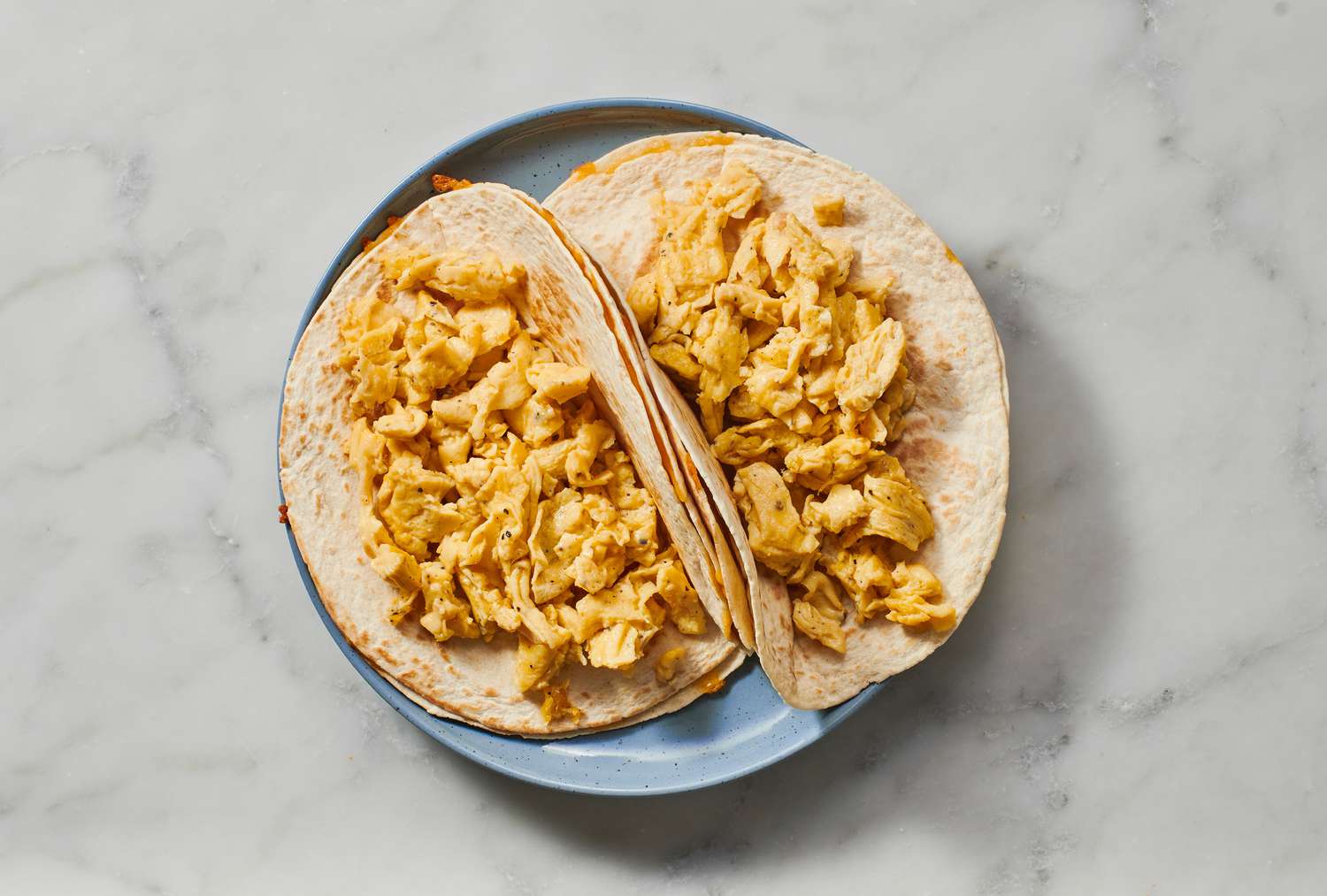 Two quesadillas topped with scrambled eggs