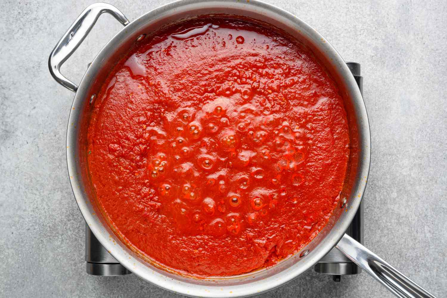 A pan with simmering chile-tomato sauce