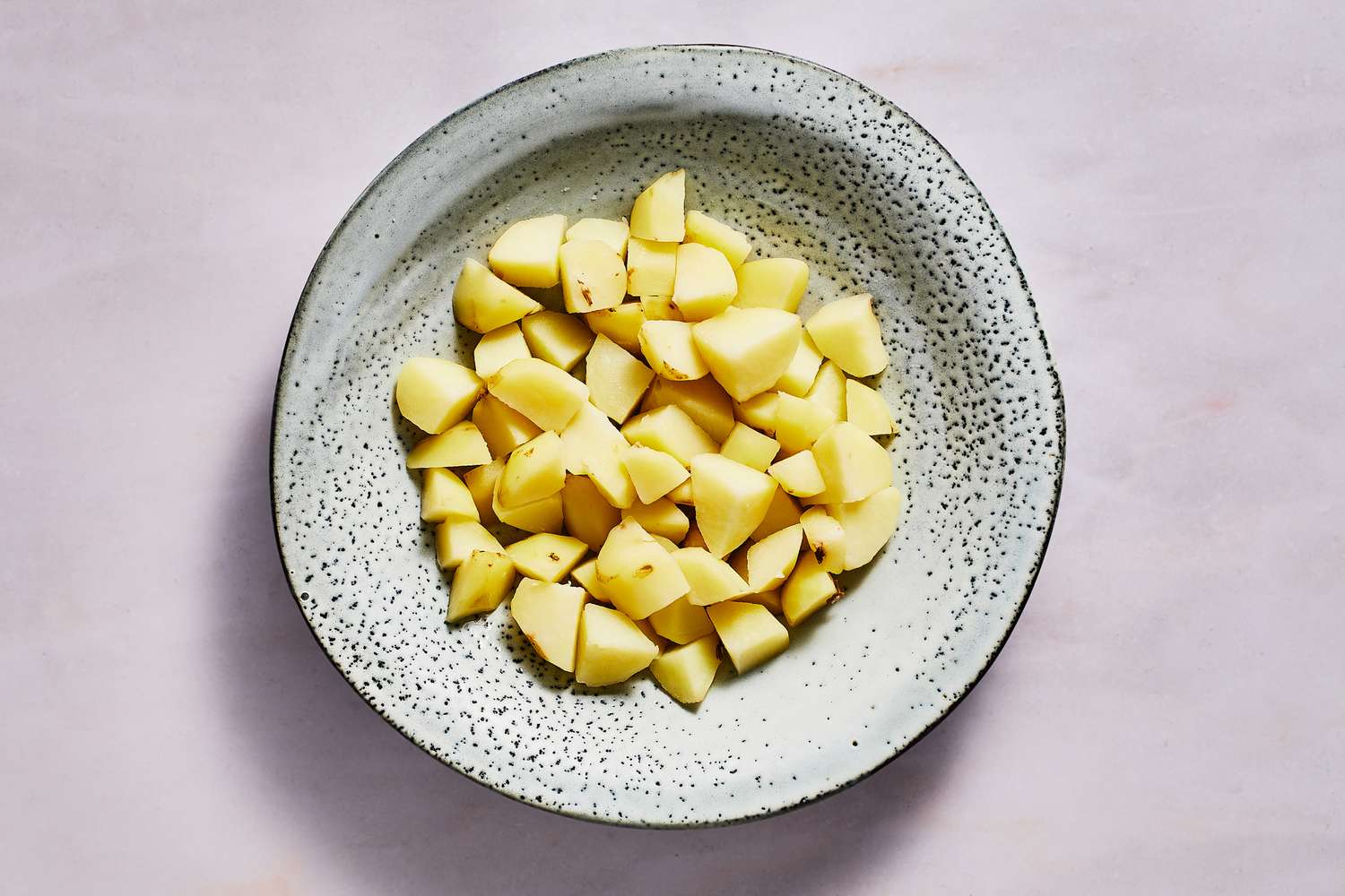 A bowl of peeled, cubed, and cooked Yukon Gold potatoes