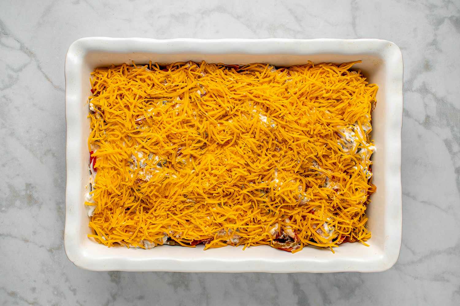 Casserole evenly covered with grated cheddar cheese