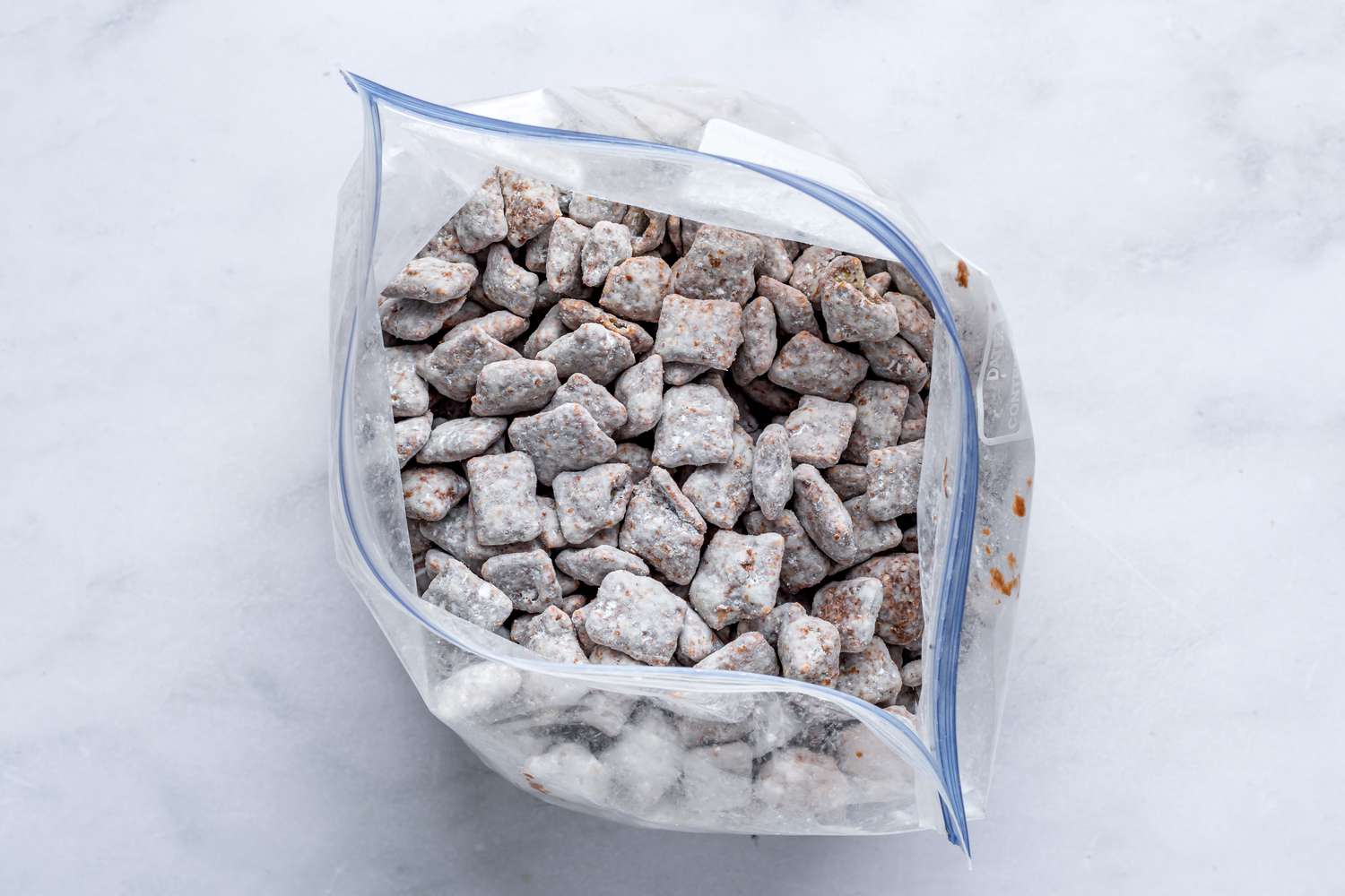 A zip top bag filled with powder sugar-coated chocolate rice cereal