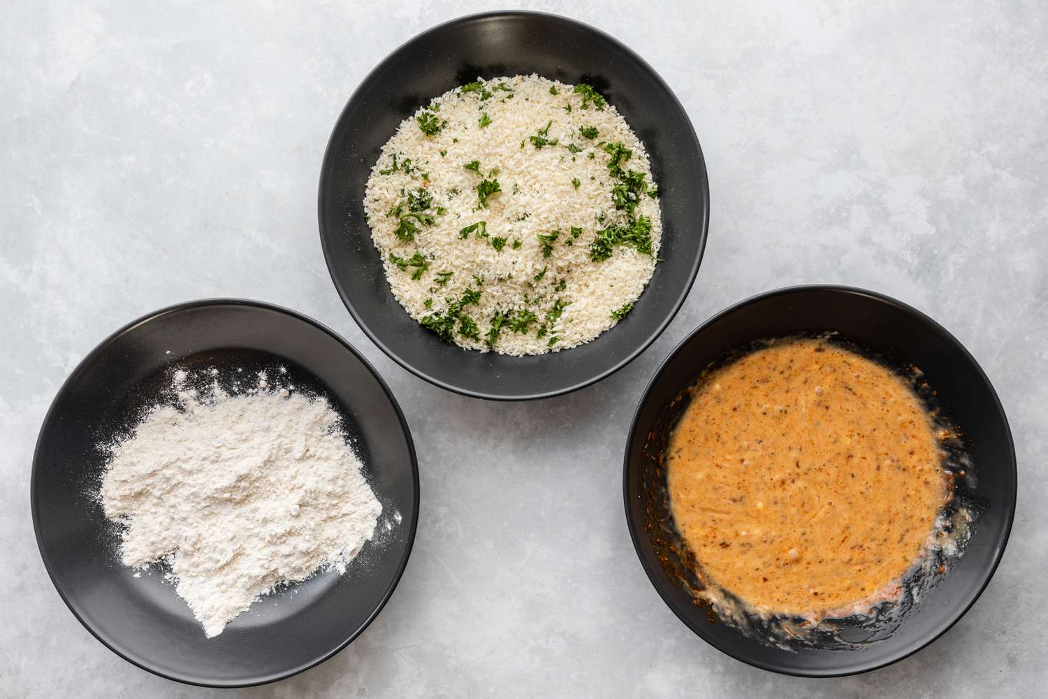 Bowls of flour, panko, and egg mixtures for haddock