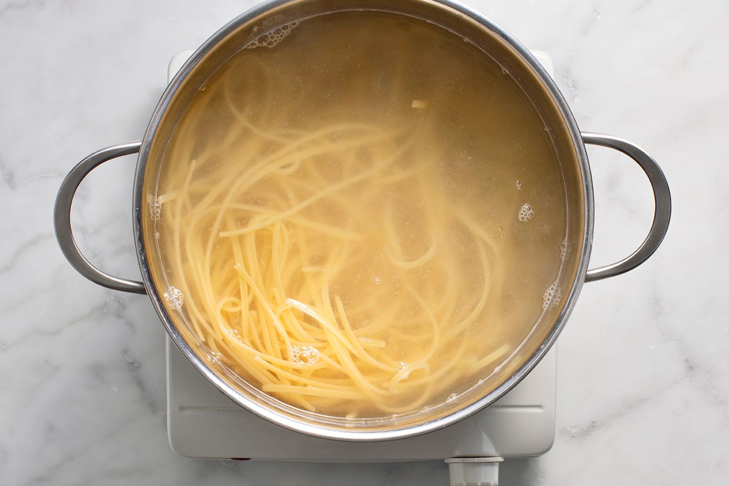 Pasta cooking in a pot on a burner 