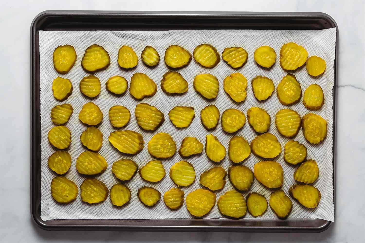 Pickles on a parchment paper lined baking sheet 