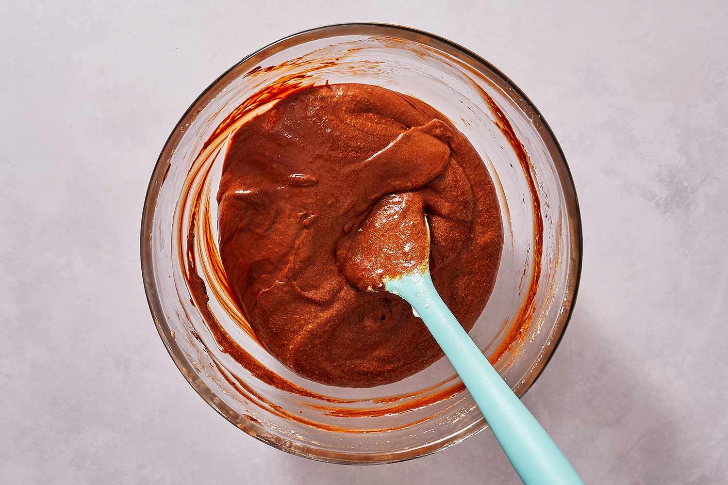 Chocolate and egg yolk mixture in a bowl with a spatula 