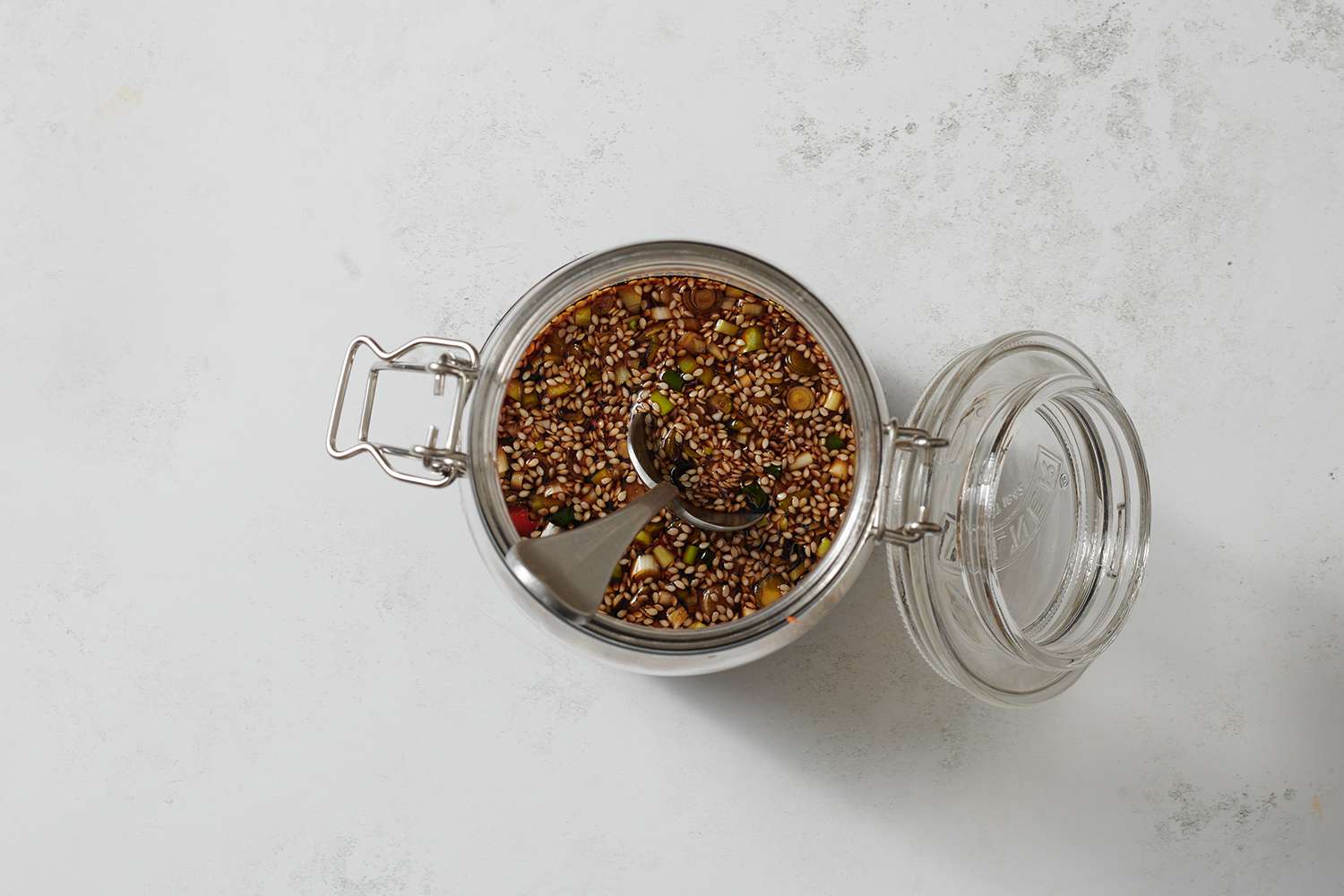 A jar of soy sauce, water, aged soy sauce, balsamic vinegar, sugar, scallions, chiles, and sesame seeds and garlic