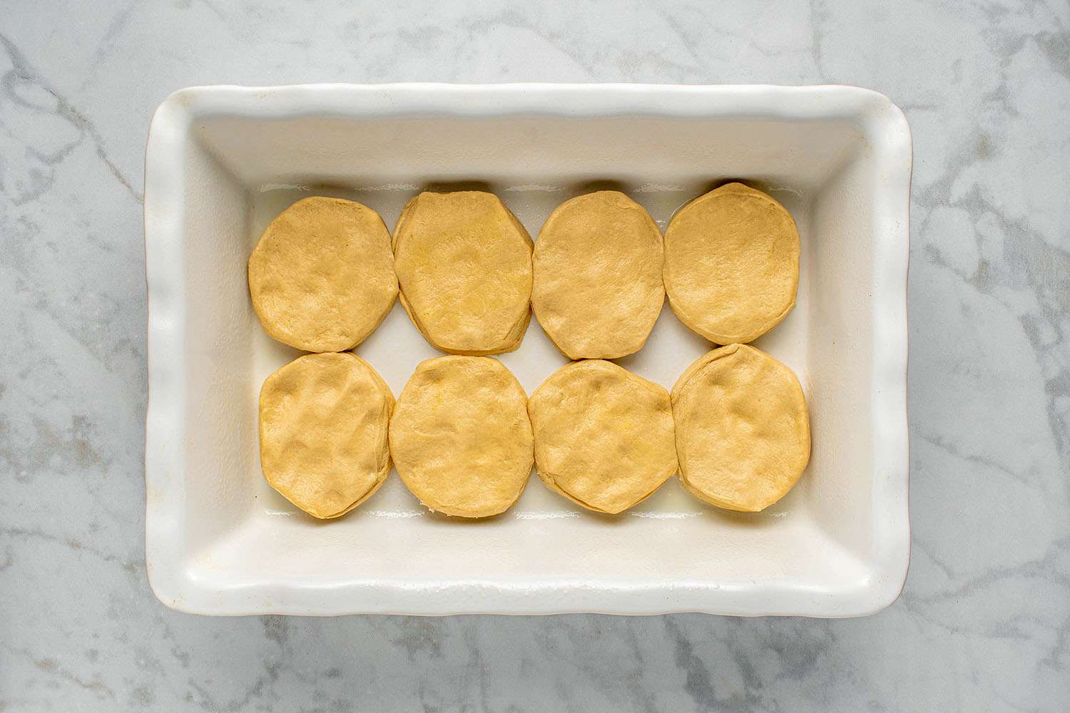 Biscuits fitting snugly in a single layer in a rectangular baking dish