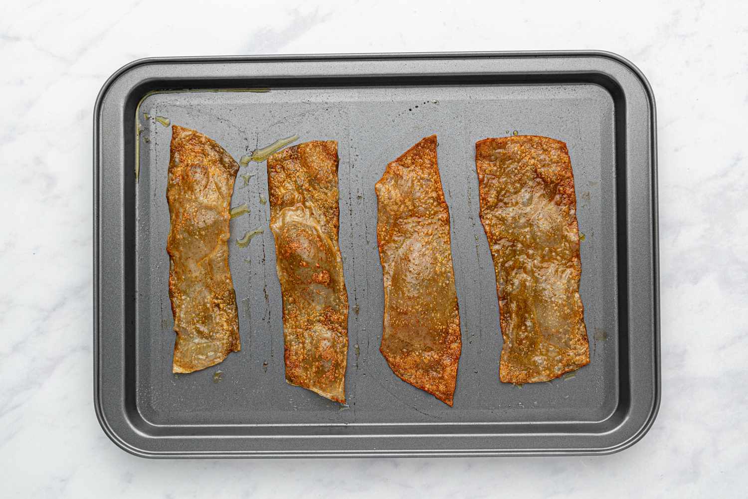 baked rice paper bacon pieces on a baking sheet 