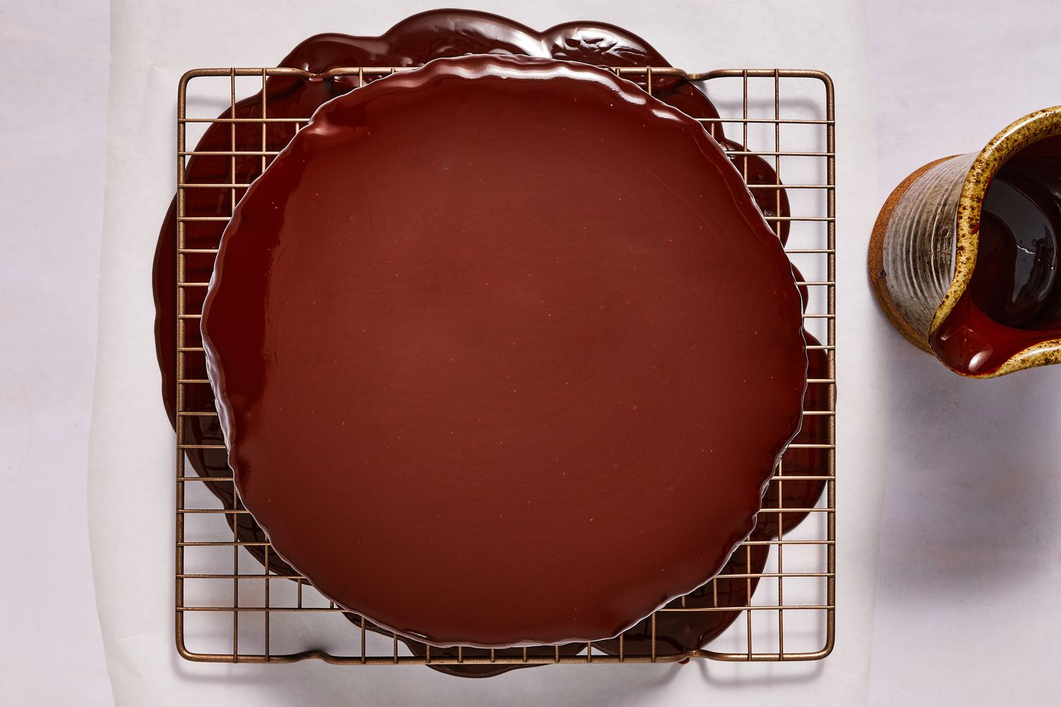 chocolate glaze poured over chocolate mousse cake on rack