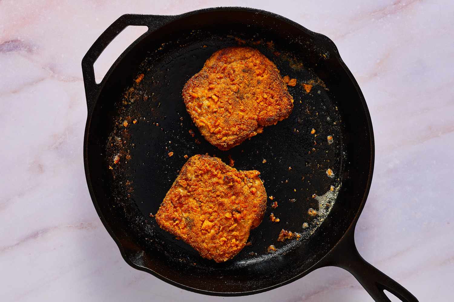 Two pieces of French toast cooking in a skillet