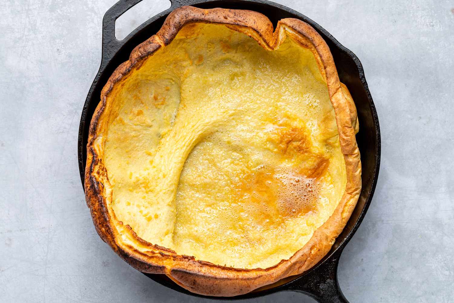 A cooked Dutch baby in a skillet