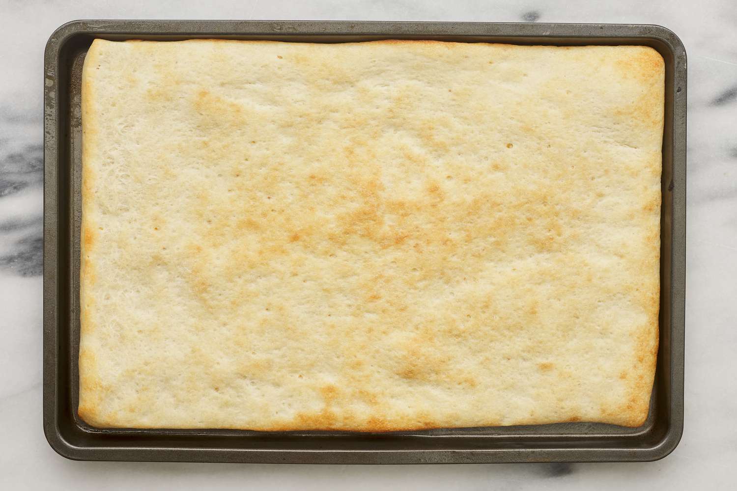 baked pizza crust on sheet tray