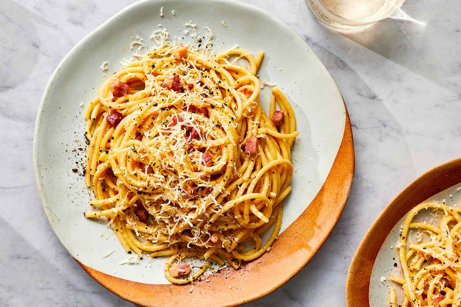 Carbonara pasta with black pepper and ground cheese on top 