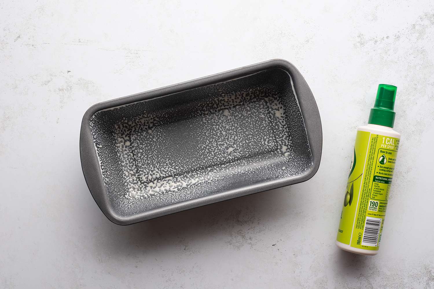 Cooking spray bootle and a greased loaf pan 