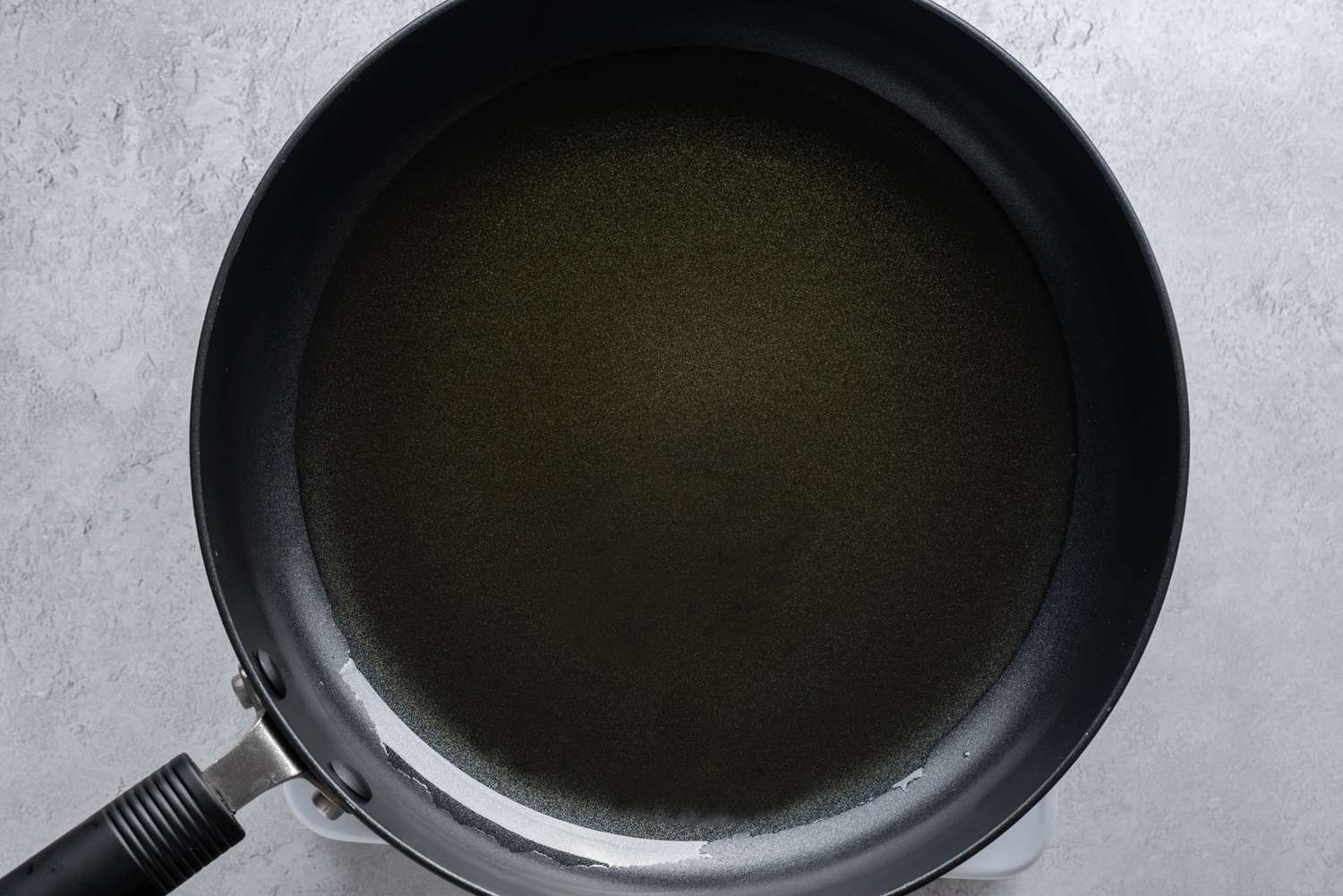 Olive oil heating in a skillet