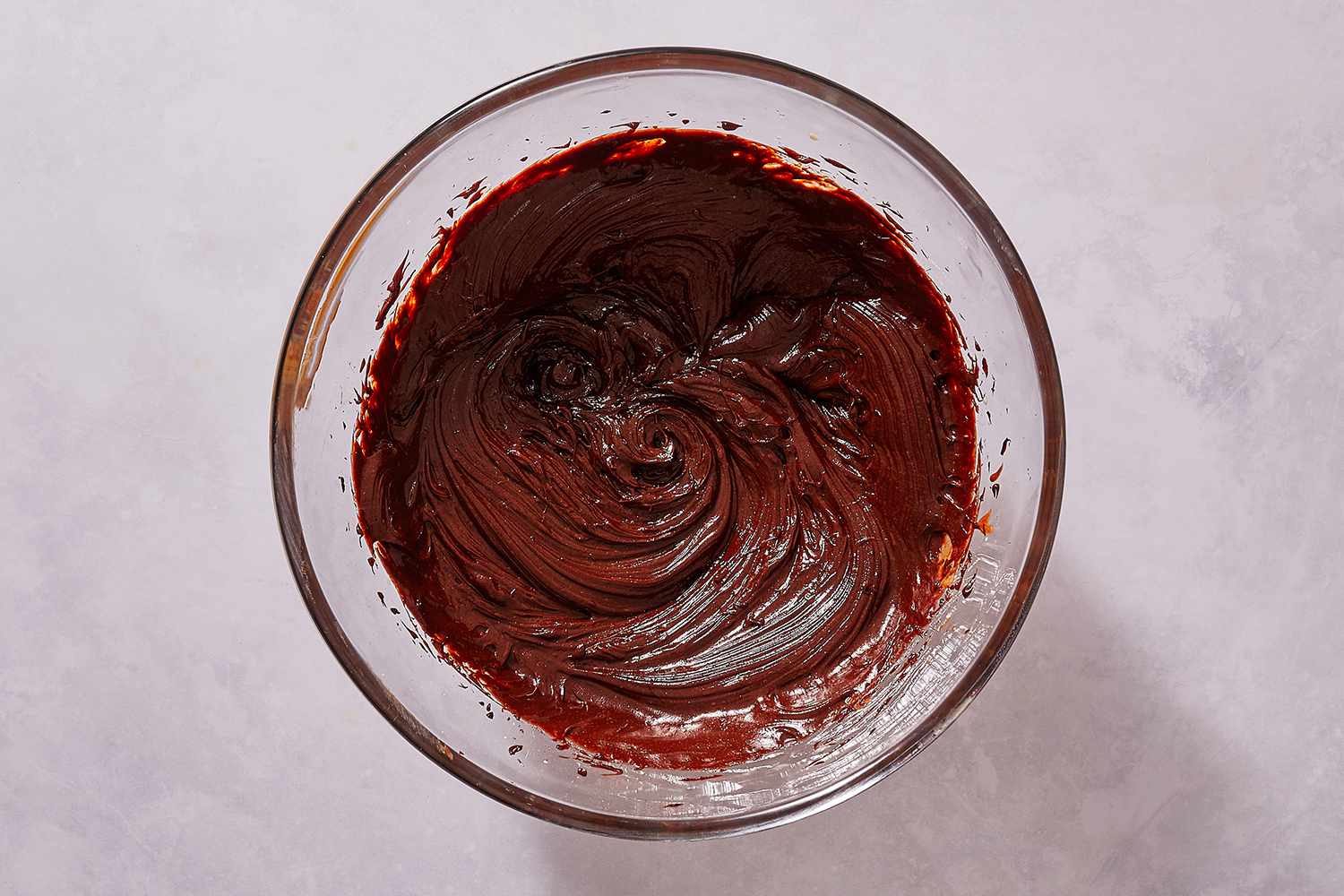 Chocolate, egg, and cream mixture in a glass bowl 