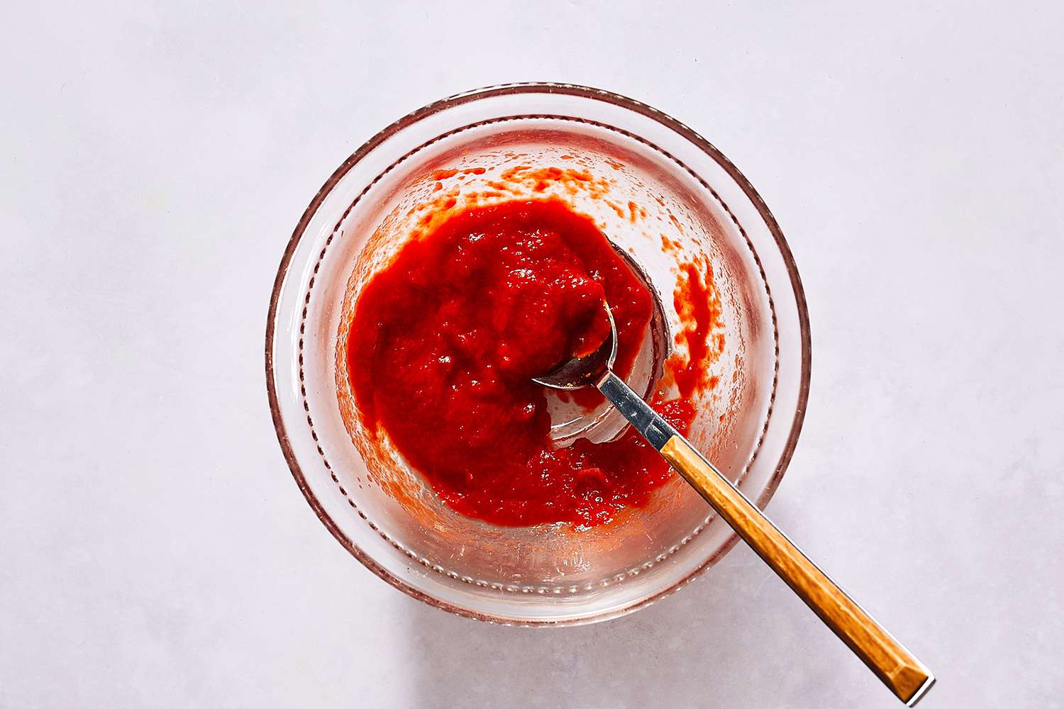 Tomato sauce in a glass bowl with a spoon