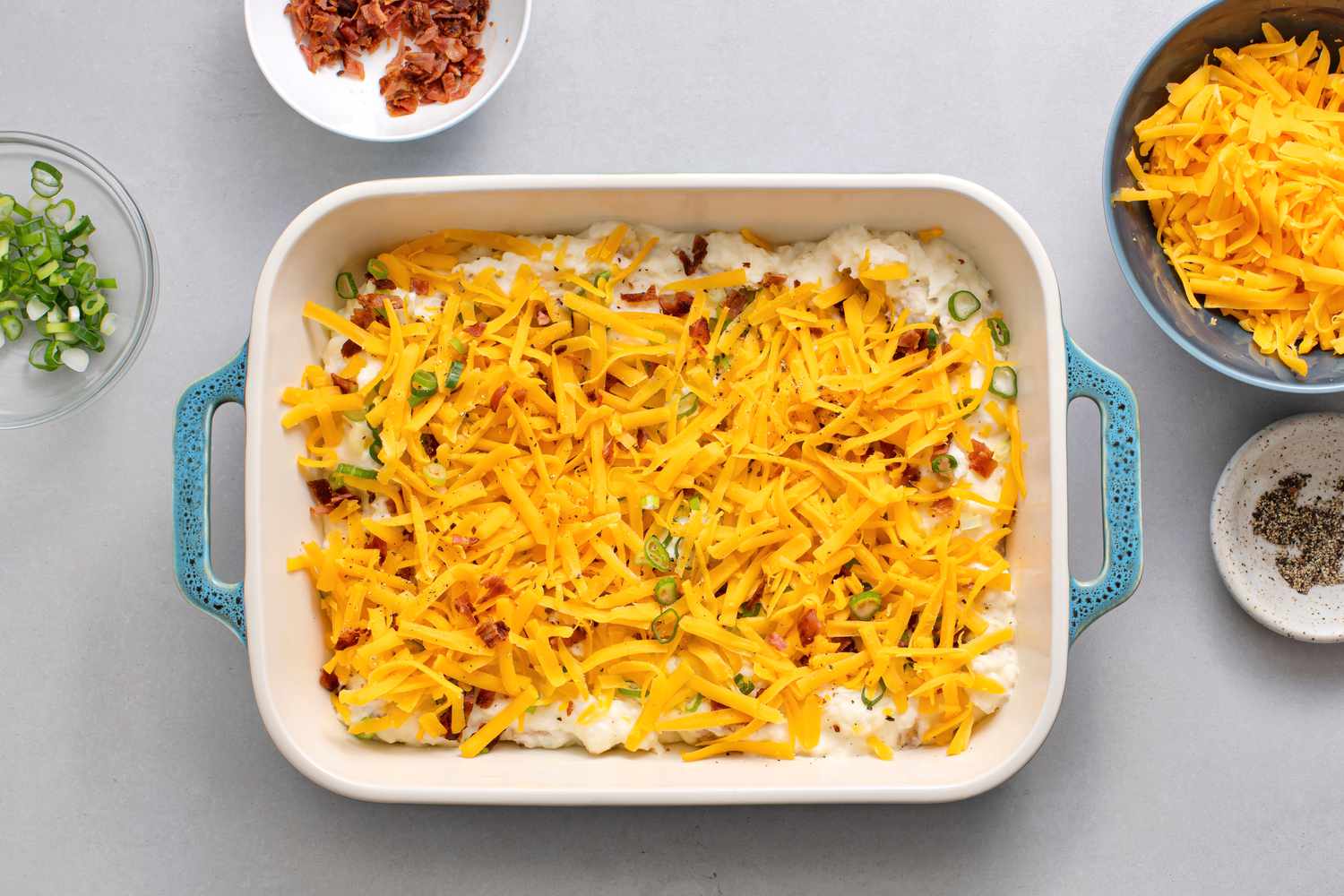 bacon, scallions, and cheddar cheese in a baking dish
